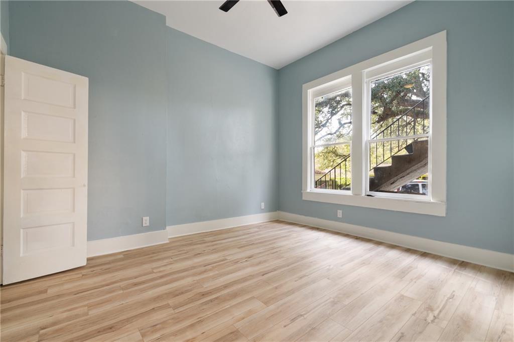 3210 Hampton Road, Unit A B C Austin, TX 78705 - Photo 28 of 42 Bright room featuring light blue walls, wood-finish flooring, white baseboards, and two tall windows with white trim
