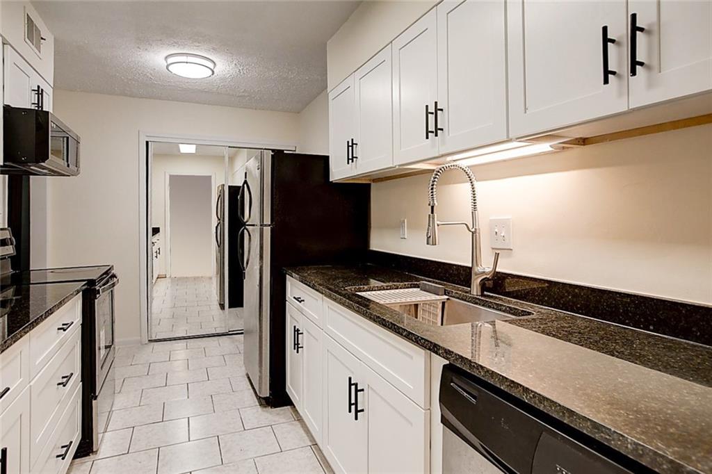 725 Dalrymple Road, Unit 3A Atlanta, GA 30328 - Photo 1 of 1 a kitchen with granite countertop a sink and stainless steel appliances