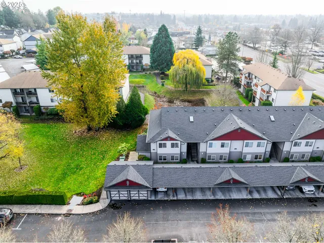 an aerial view of a house with a garden and lake view