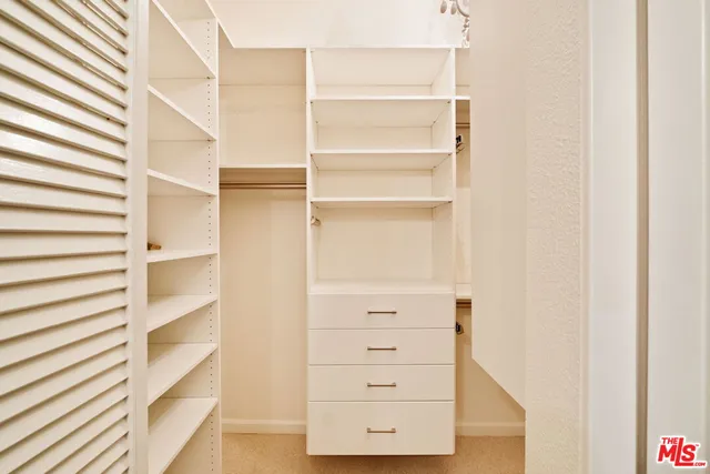 a view of walk in closet with empty racks