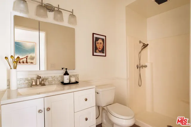 a bathroom with a granite countertop sink mirror vanity and toilet