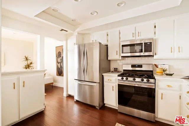 a kitchen with stainless steel appliances a stove a microwave and a refrigerator