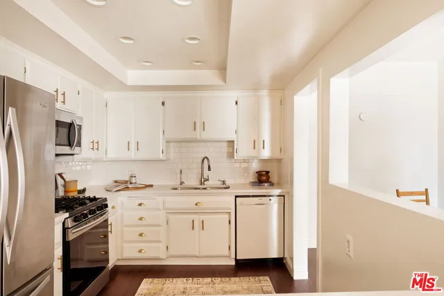 a kitchen with granite countertop a sink stove and refrigerator