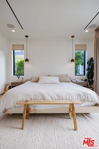 a bedroom with a bed and a large window