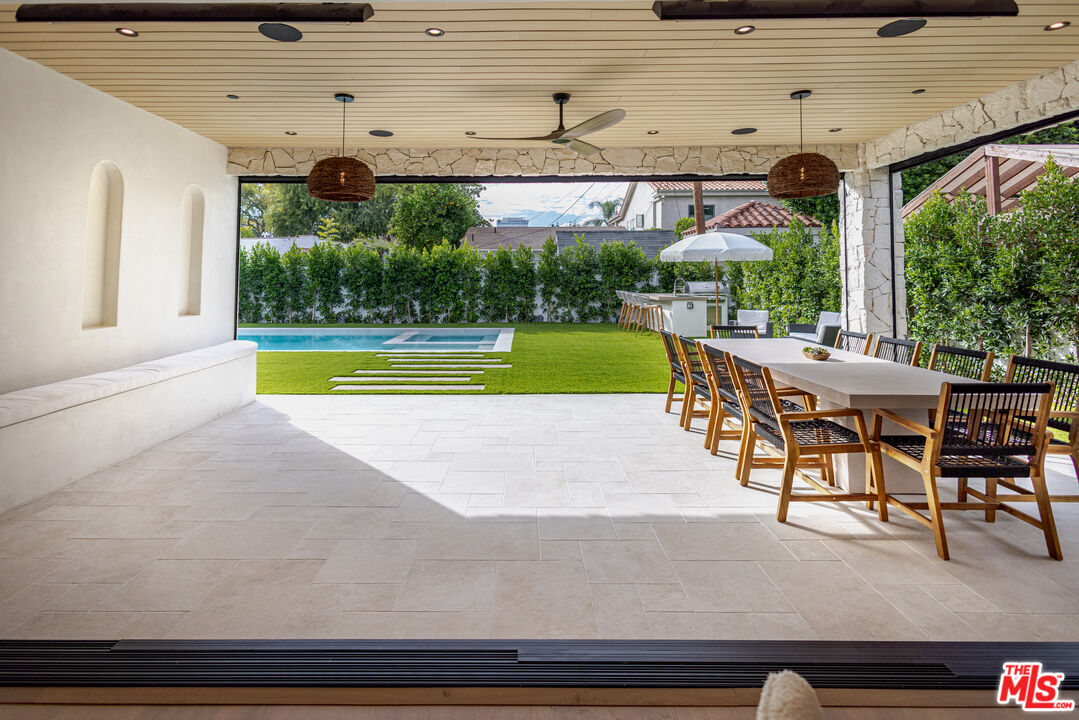 4703 Saloma Avenue Sherman Oaks, CA 91403 - Photo 23 of 26 a view of a swimming pool with a table and chairs under an umbrella