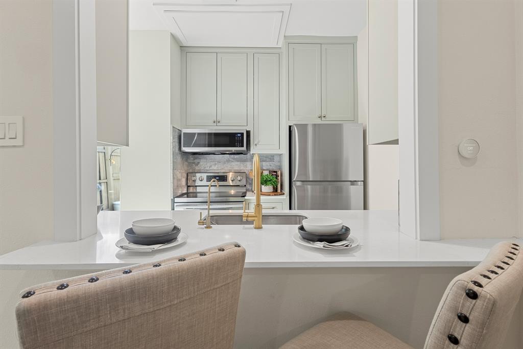 2806 Knight Street, Unit 103 Dallas, TX 75219 - Photo 6 of 17 a kitchen with a sink and a refrigerator