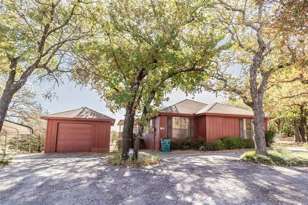 a front view of a house with yard and trees