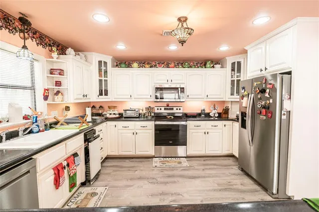 a kitchen with stainless steel appliances kitchen island granite countertop a refrigerator and a stove top oven