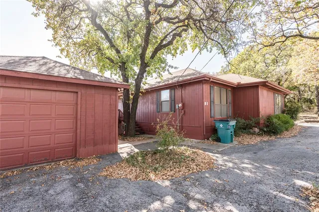a view of a house with a large tree and wooden fence