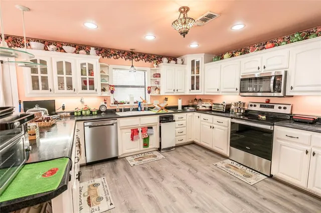 a kitchen with stainless steel appliances granite countertop a stove and a sink