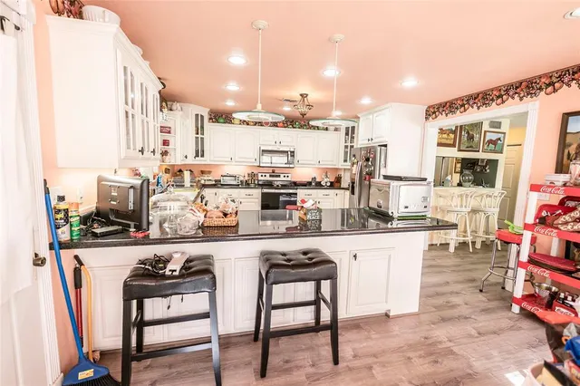 a kitchen with stainless steel appliances kitchen island granite countertop a sink and cabinets