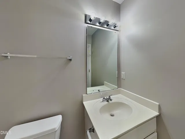 a bathroom with a sink toilet and mirror