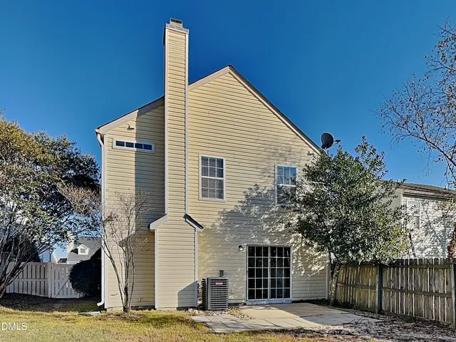 a front view of a house with a tree