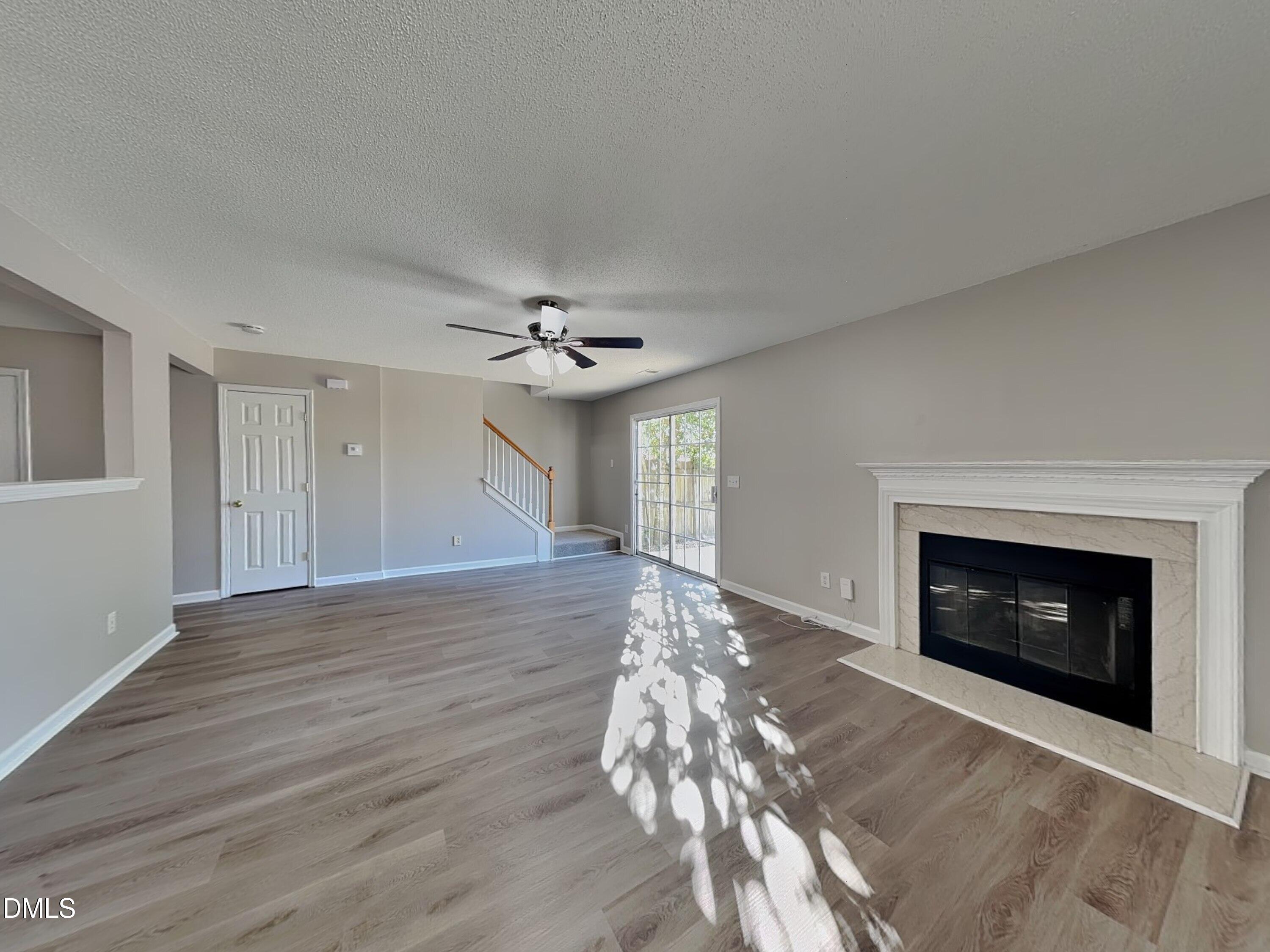 8109 Bright Oak Trail Raleigh, NC 27616 - Photo 3 of 15 a view of an empty room with wooden floor fireplace and a window