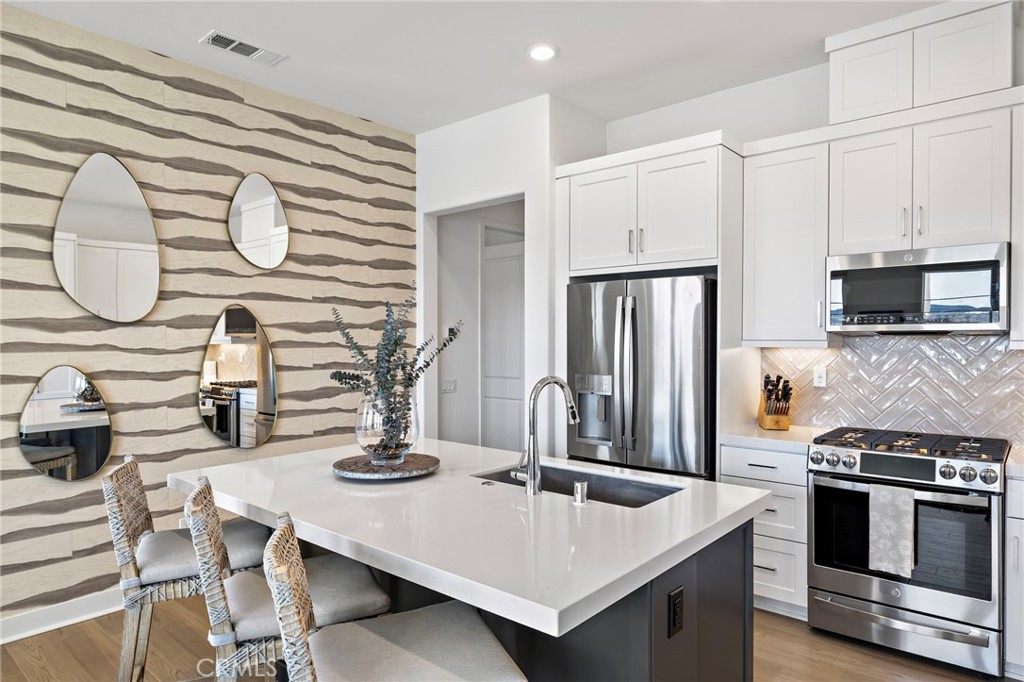 896 Sunrise Road Rancho Mission Viejo, CA 92694 - Photo 13 of 42 a kitchen with stainless steel appliances granite countertop a sink stove and refrigerator