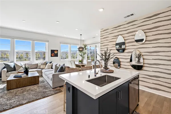 a kitchen with a sink a counter top space and living room area