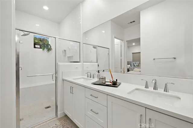 a bathroom with a double vanity sink mirror and shower