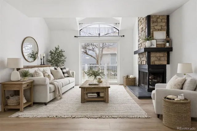 a living room with furniture a fireplace and a table