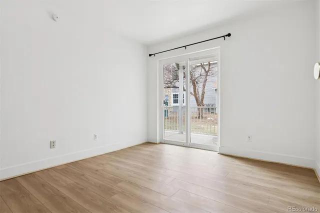 an empty room with wooden floor and door