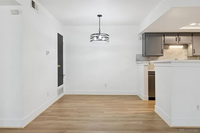 a view of a kitchen with wooden floor and a ceiling fan