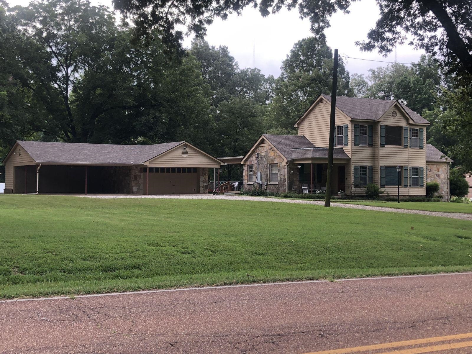 a front view of a house with a garden and yard