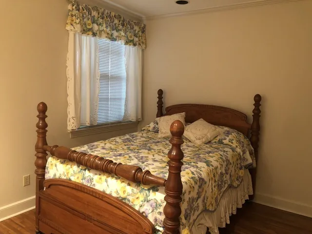 a bed sitting in a bedroom next to a window