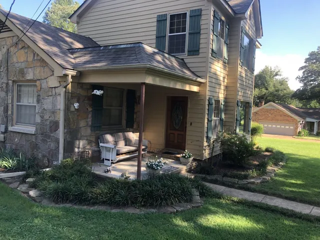 a view of a chair and table in backyard of the house
