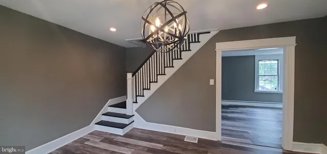 a view of entryway and hall with wooden floor