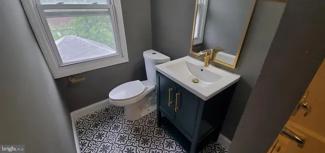 a bathroom with a sink a toilet a mirror and window