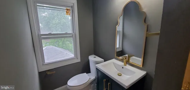 a bathroom with a sink toilet and a mirror