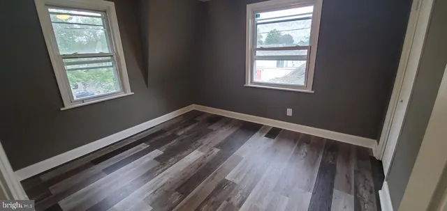 a view of a room with wooden floors and window