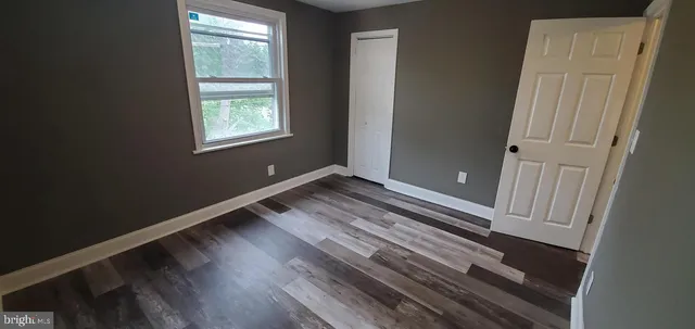 a view of a room with wooden floor and a window