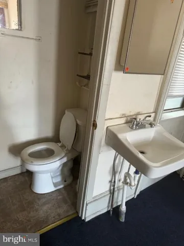a white toilet sitting next to a bathroom sink