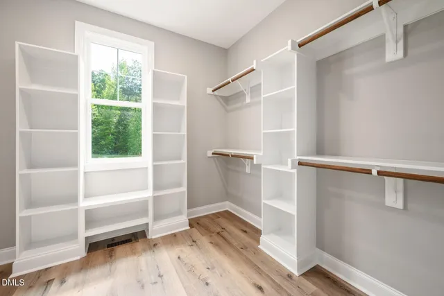 a view of walk in closet with empty racks