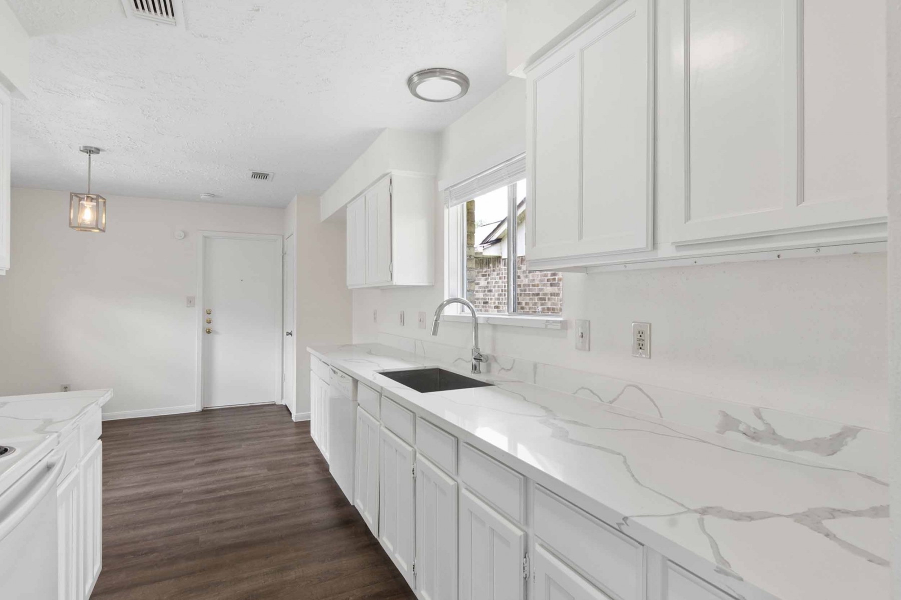 10411 Rabbit Oak Drive Houston, TX 77065 - Photo 11 of 22 Bright kitchen features sleek white cabinets, elegant quartz countertops, and a modern sink setup.