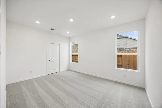 an empty room with a window and a bathroom