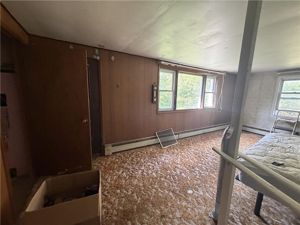 5114 Three Lakes Road New Milford, PA 18834 - Photo 19 of 55 Vintage wood paneling and patterned carpeting define this retro-inspired bedroom space.