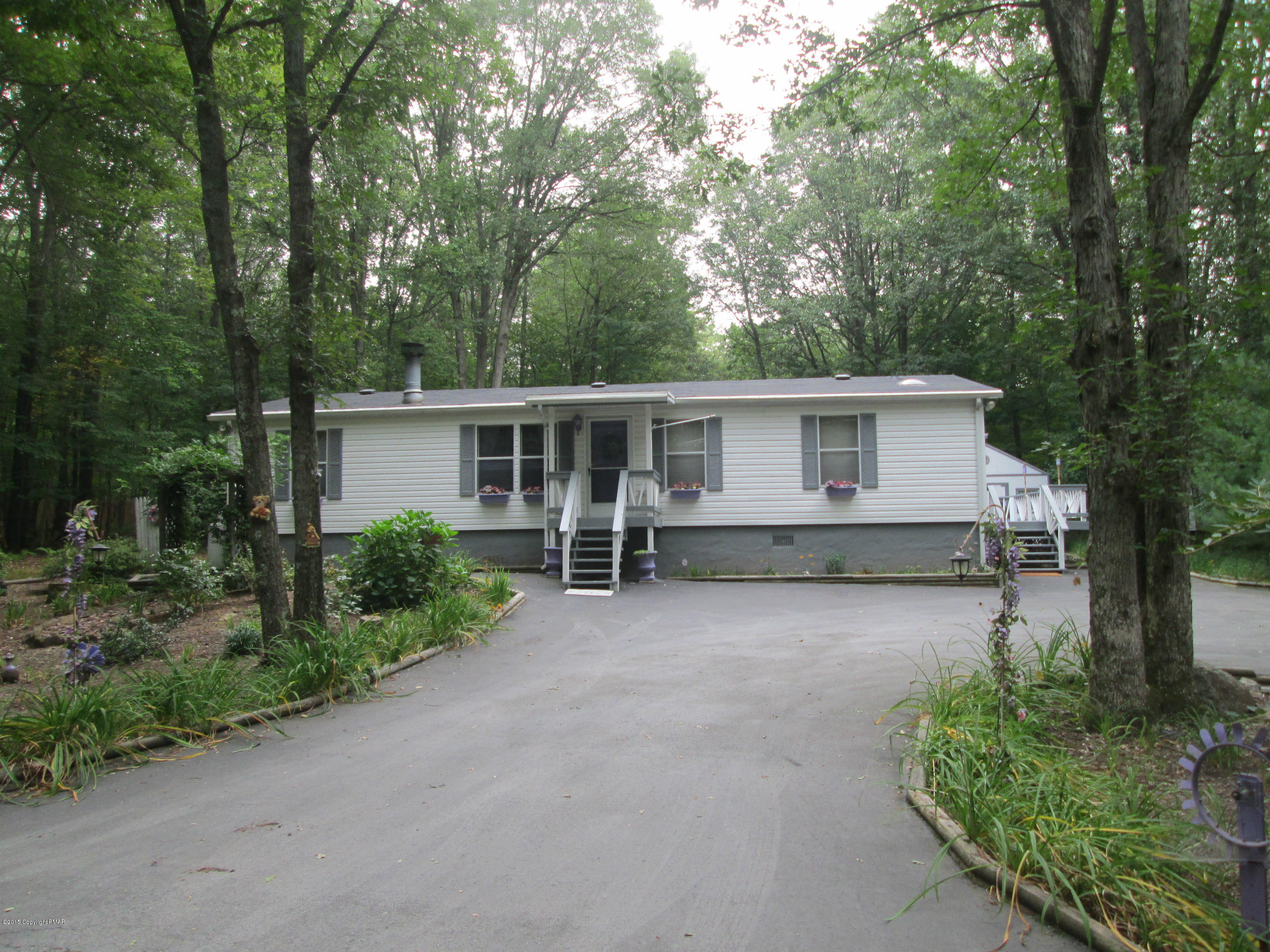 front view of a house with a yard and potted plants