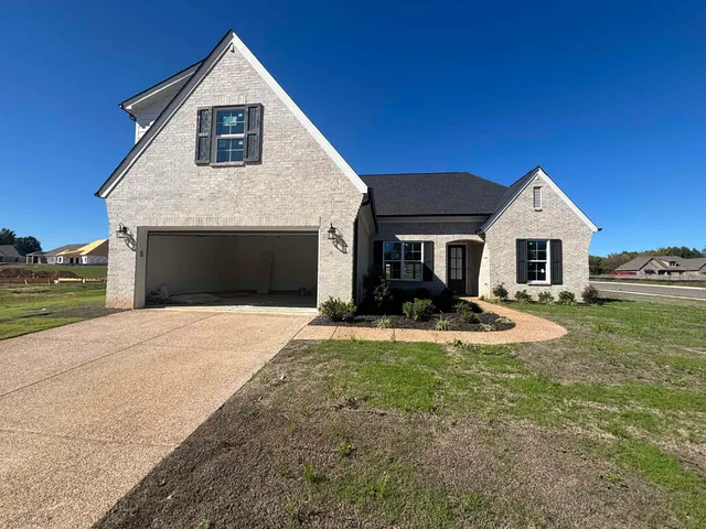 a front view of a house with yard and garage