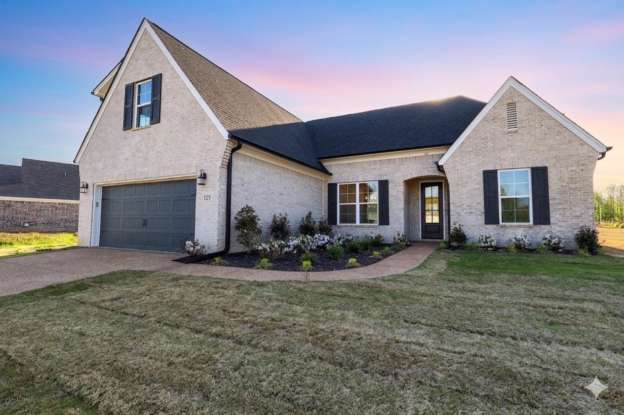 125 Columbia Way Atoka, TN 38004 - Photo 1 of 27 View of front of home with brick siding, a front yard, a shingled roof, and driveway