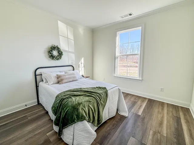 a bed sitting in a bedroom next to a window