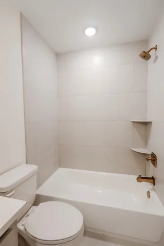 a bathroom with a white toilet and a bath tub
