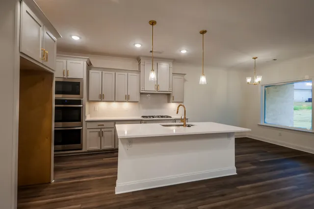 a kitchen with kitchen island a sink stainless steel appliances and cabinets
