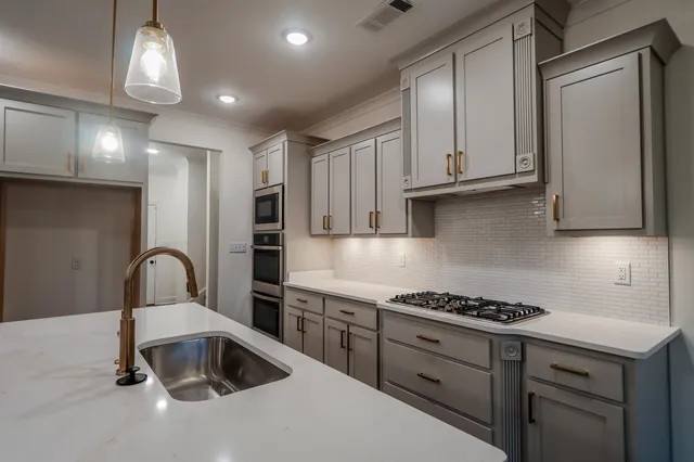 a kitchen with granite countertop a stove and a sink