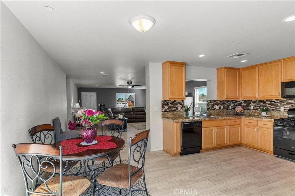784 Taryn Court Merced, CA 95341 - Photo 15 of 39 a kitchen with stainless steel appliances kitchen island granite countertop a dining table and chairs