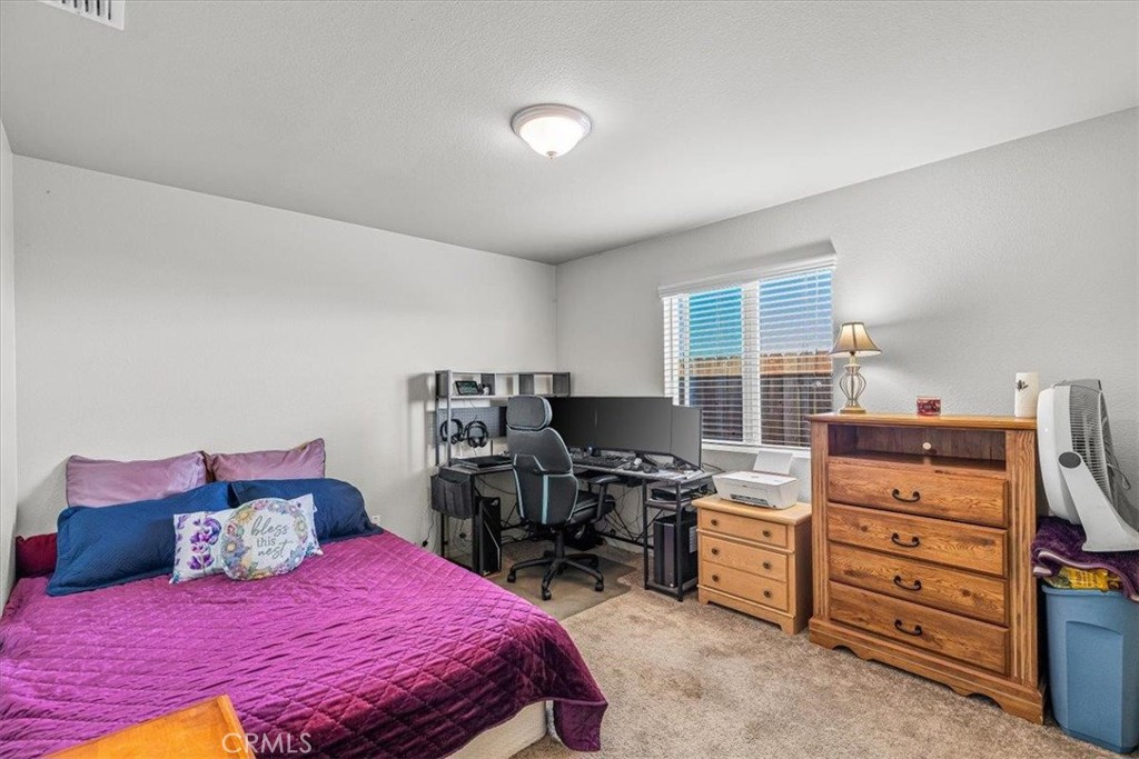 784 Taryn Court Merced, CA 95341 - Photo 27 of 39 a bedroom with a bed and a book shelf