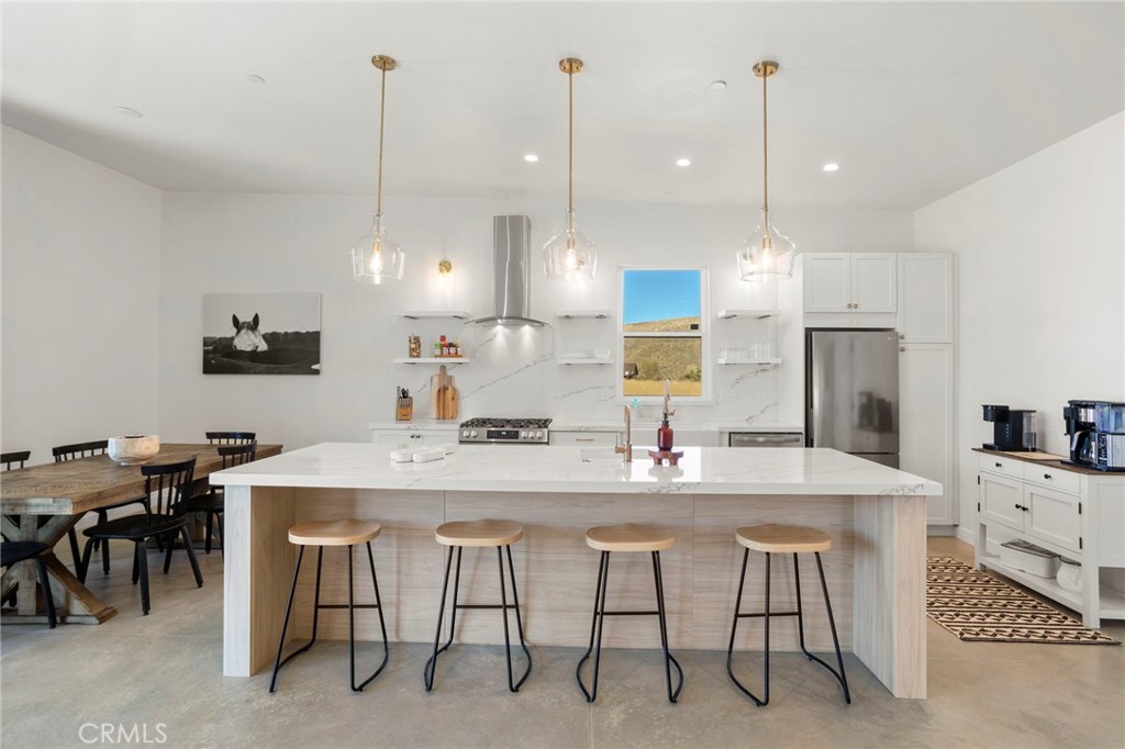 5145 Tom Mix Road Pioneertown, CA 92268 - Photo 25 of 75 a kitchen with stainless steel appliances kitchen island granite countertop a table a stove and a cabinets