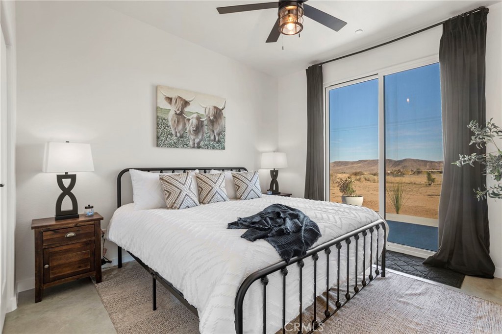 5145 Tom Mix Road Pioneertown, CA 92268 - Photo 32 of 75 a bedroom with a bed and a chandelier
