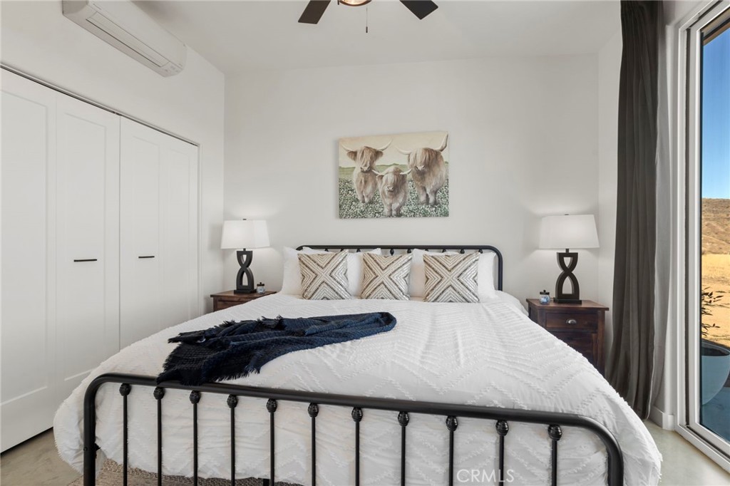 5145 Tom Mix Road Pioneertown, CA 92268 - Photo 33 of 75 a bedroom with a bed and a painting on the wall