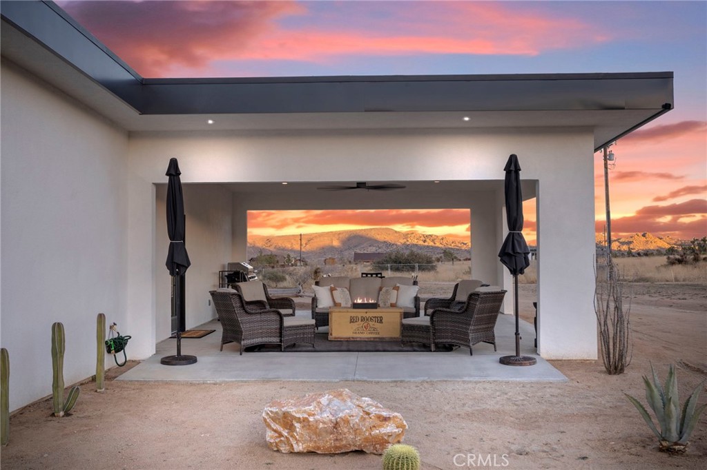 5145 Tom Mix Road Pioneertown, CA 92268 - Photo 65 of 75 a living room with furniture a floor to ceiling window and a flat screen tv